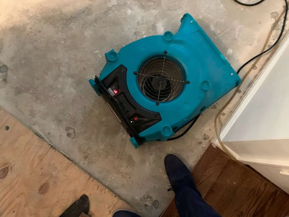 Air mover drying subfloor during Commercial Water Damage Restoration in Gilberts
